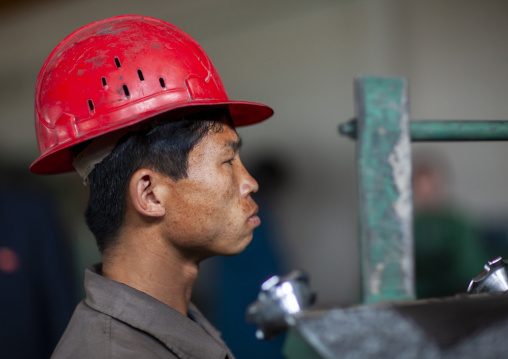 North Korean worker with a red helmet in a steel factory, South Pyongan, Nampo, North Korea