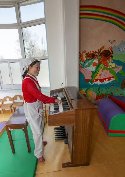 Nurse playing organ in an orphanage, South Pyongan, Nampo, North Korea