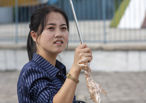North Korean woman with a umbrella in the street, DGC, Pyongyang, North Korea