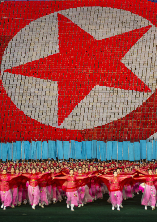 Women dancing in front of giant north korean flag during the Arirang, DGC, Pyongyang, North Korea