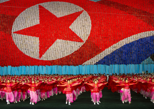 Women dancing in front of giant north korean flag during the Arirang, DGC, Pyongyang, North Korea
