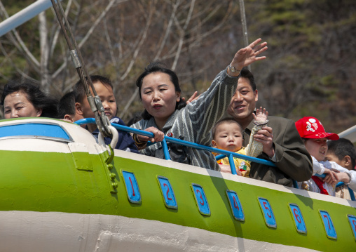 People having fun on a plane attraction in Taesongsan funfair, DGC, Pyongyang, North Korea