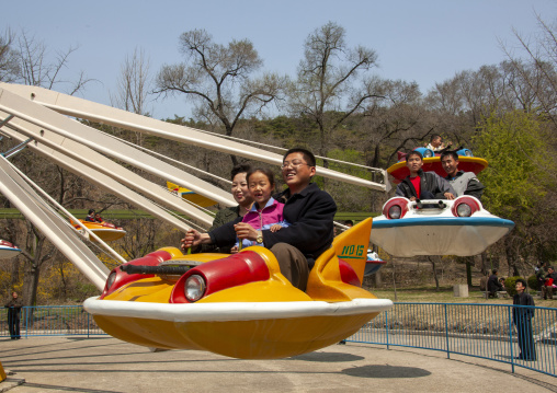 People having fun on a flying saucer attraction in Taesongsan funfair, DGC, Pyongyang, North Korea