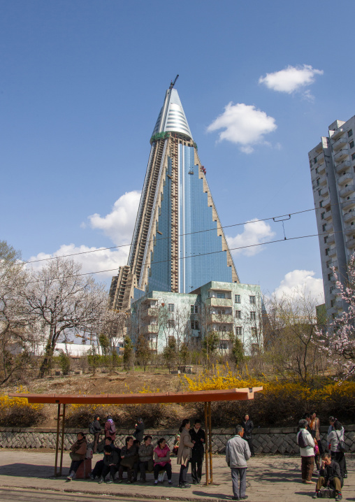 Bus stop in front of the pyramid-shaped Ryugyong hotel, DGC, Pyongyang, North Korea