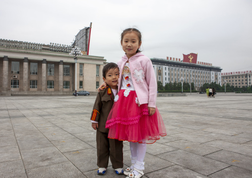 Boy dressed in soldier with his sister on Kim il Sung square, DGC, Pyongyang, North Korea