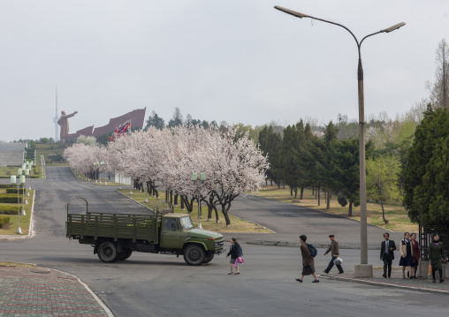 North Korean man walking with Kim il Sung statue in the background, DGC, Pyongyang, North Korea