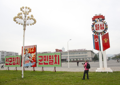 Tourist taking pictures of propaganda billboards, Kangwon Province, Wonsan, North Korea