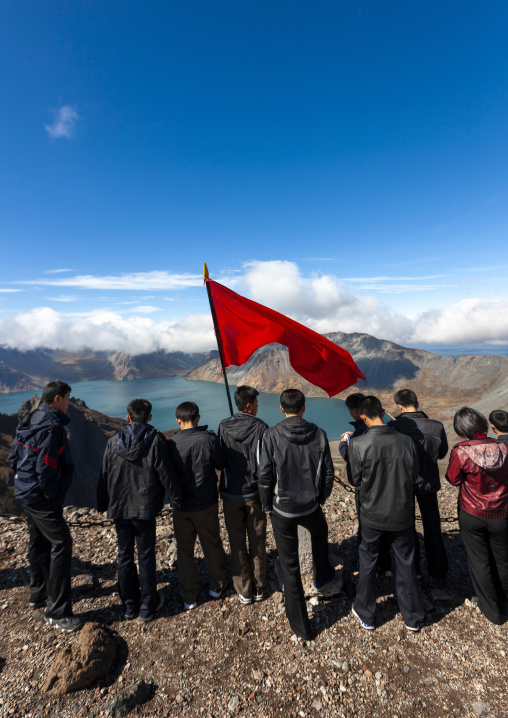Group of students with red flag in front of lake at mount Paektu, Ryanggang, Mount Paektu, North Korea