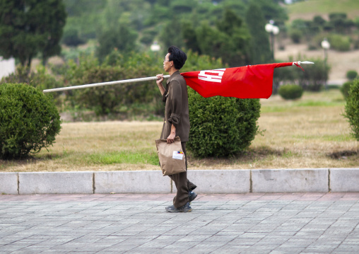 North korean man with a red flag in the street, DGC, Pyongyang, North Korea