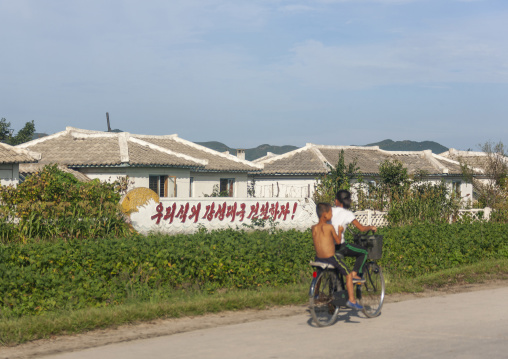 People near propaganda billboards, South Pyongan, Chongsan-ri Cooperative Farm, North Korea