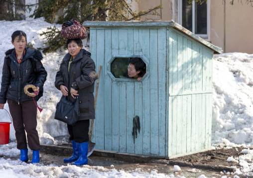 North Korean woman looking thru the window of a small gatehouse, Ryanggang, Samjiyon, North Korea