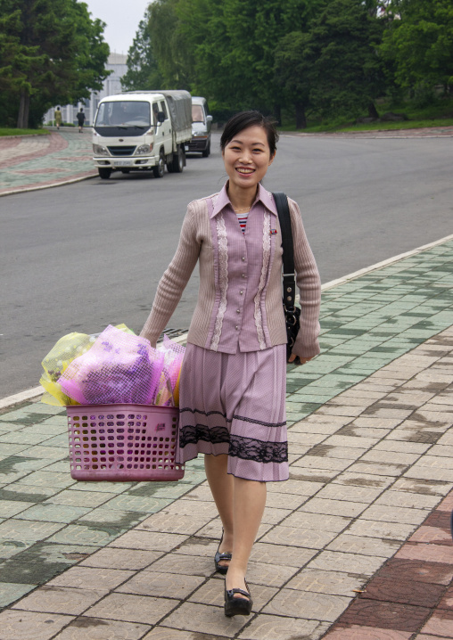 Smiling woman with a bunch of flowers in Mansudae Grand monument, DGC, Pyongyang, North Korea