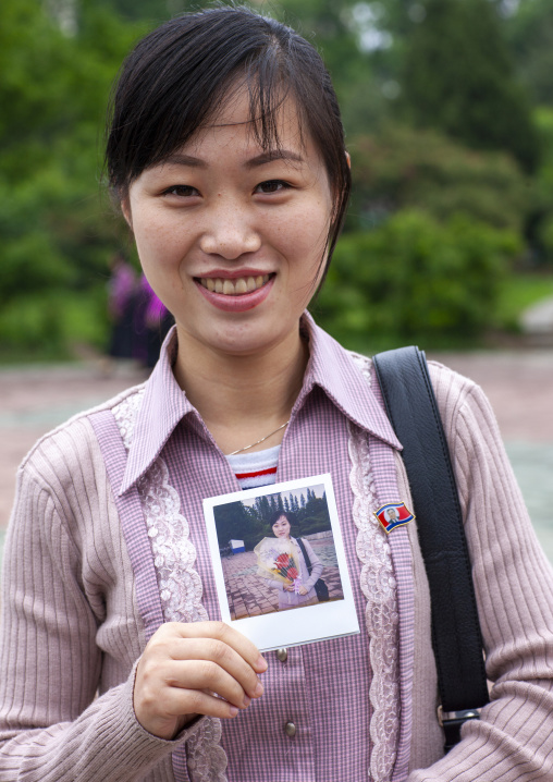 Portrait of a smiling North Korean woman with her polaroid, DGC, Pyongyang, North Korea