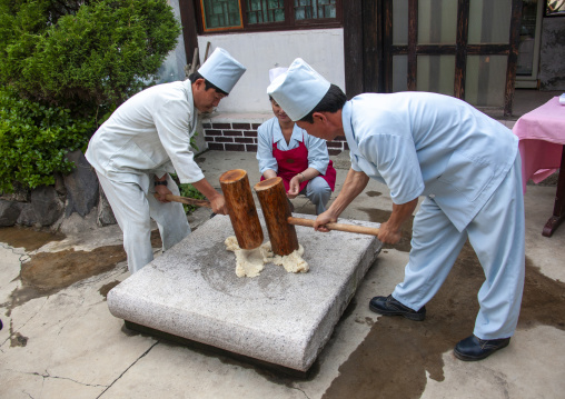 Cooks banging rice to make tteok in a restaurant, North Hwanghae, Kaesong, North Korea