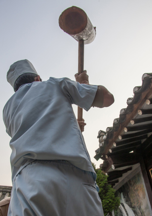 Cook banging rice to make tteok in a restaurant, North Hwanghae, Kaesong, North Korea