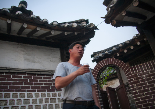North Korean guide drinking soju in Folk hotel, North Hwanghae, Kaesong, North Korea