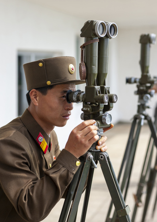 North Korean soldier looking south Korea with binoculars at the DMZ, North Hwanghae, Panmunjom, North Korea