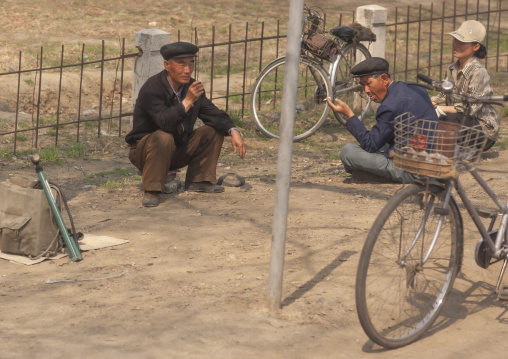 North Korean people resting near bicycles along the road,Pyongyang, DGC, North Korea
