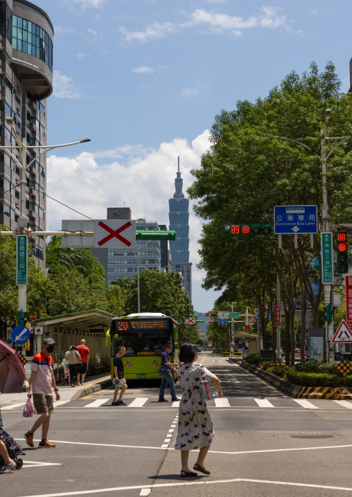 Taiwanese people crossing a road in front of 101 tower, Daan District, Taipei, Taiwan
