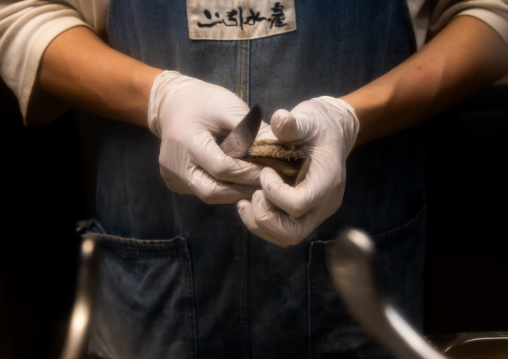 Man opening an abalone in the fish market, Zhongshan District, Taipei, Taiwan