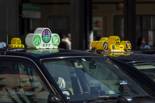Close-up of illuminated taxi roof signs with Japanese characters