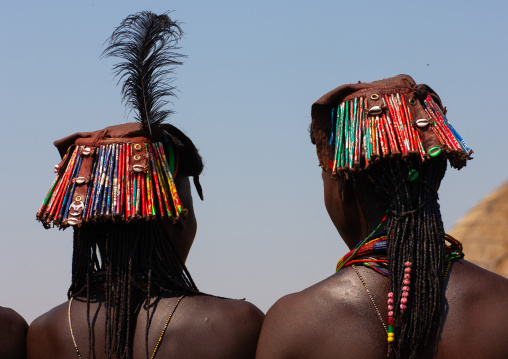 Muhacaona tribe women with kapapo headdress made of soda cans, Cunene Province, Oncocua, Angola