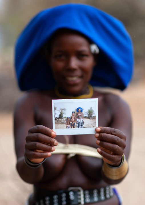 Mucubal tribe woman showing a polaroid, Namibe Province, Virei, Angola