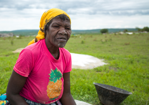 Angolan woman grinding grain to make flour, Huila Province, Caconda, Angola