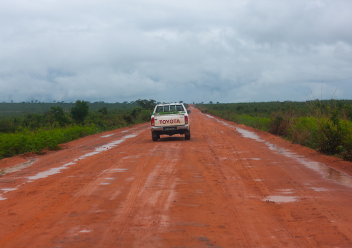 Car driving on a dirt road in the bush, Bié Province, Kuito, Angola
