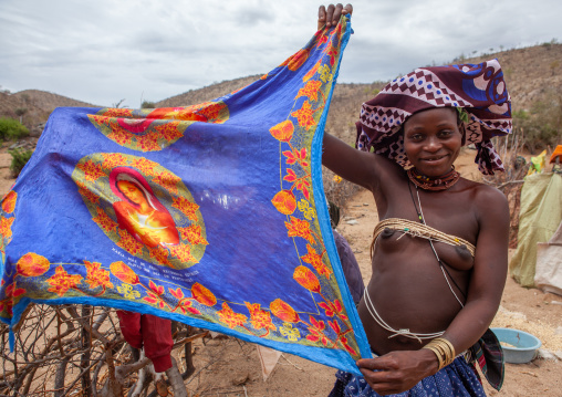Mucubal tribe woman showing a cloth with jesus portrait on it, Namibe Province, Virei, Angola