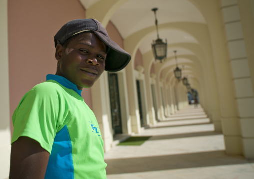 Teenager With A Cap In Front Of The National Bank Of Angola In Luanda, Angola