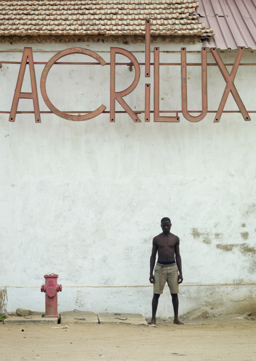 Man In Front Of An Acrilux Old Store In Benguela, Angola