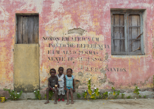 Children In Front Of An Old Communist Propaganda Message Written On Facade, Bilaiambundo, Angola