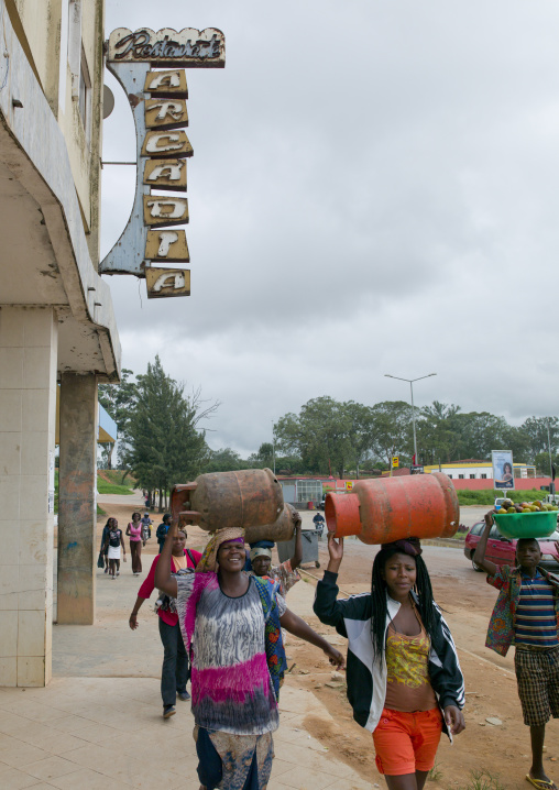 Women Carrying Bottles Of Gas On Their Head In The Street, Huambo, Angola