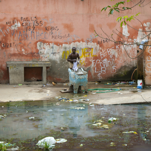 Man Doing His Laundrey In The Courtyard Of The Former Grande Hotel, Now A Squat, Luanda, Angola