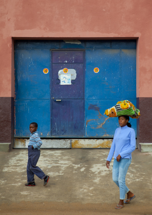 Boy And Woman Carrying A Load On Her Head In Lubango Streets, Angola