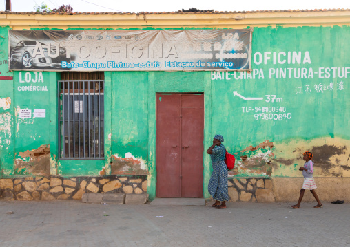 Angolan people passing in front of a garage, Benguela Province, Benguela, Angola