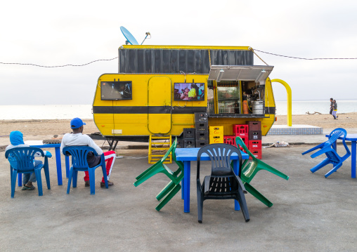 Angolan people watching television in a bar on miragens beach, Namibe Province, Namibe, Angola