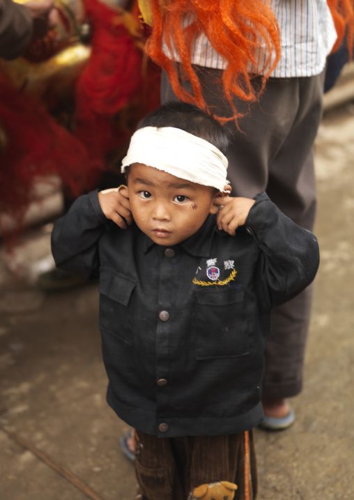 Kid Putting His Fingers In His Ears During A Funeral Procession, Yuanyang, Yunnan Province, China