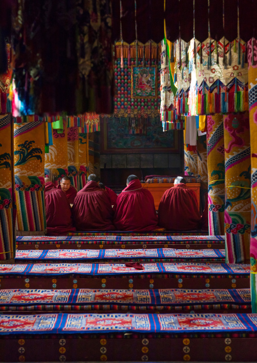 Monks praying and meditating inside Longwu monastery, Tongren County, Longwu, China