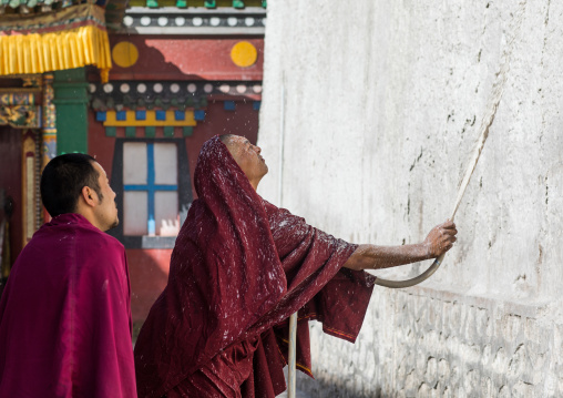 Monks painting the walls of a temple in Rongwo monastery, Tongren County, Longwu, China