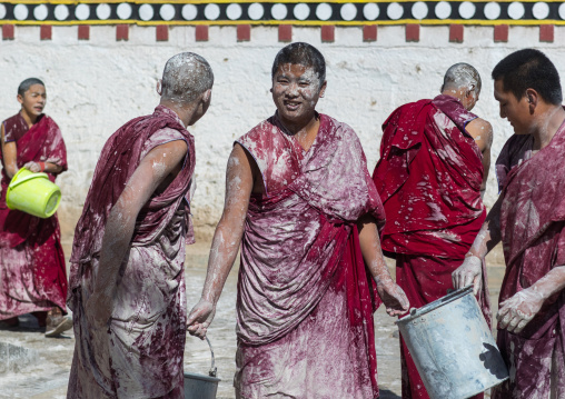 Tibetan monks enjoying a water fight after the yearly renovation of the Rongwo monastery, Tongren County, Longwu, China