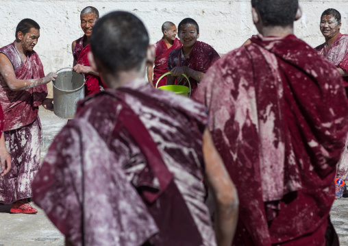 Tibetan monks enjoying a water fight after the yearly renovation of the Rongwo monastery, Tongren County, Longwu, China