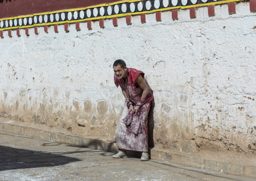 Tibetan monks enjoying a water fight after the yearly renovation of the Rongwo monastery, Tongren County, Longwu, China