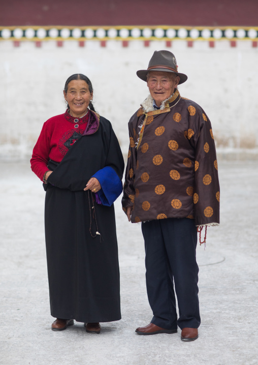 Portrait of a tibetan couple in traditional clothing in Rongwo monastery, Tongren County, Longwu, China