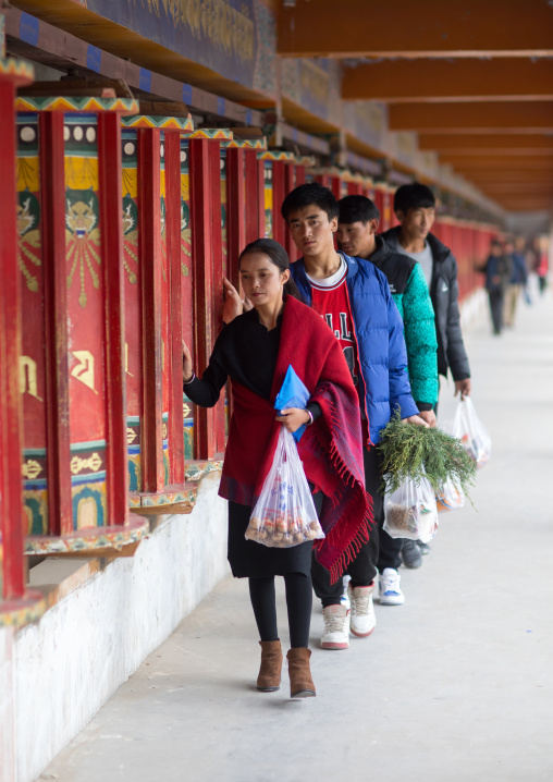Tibetan pilgrims turning prayer wheels in a Rongwo monastery, Tongren County, Longwu, China