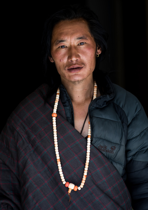 Portrait of a tibetan nomad man with a necklace, Qinghai province, Tsekhog, China