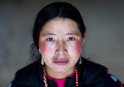 Portrait of a tibetan nomad woman with her cheeks reddened by the harsh weather, Qinghai province, Tsekhog, China