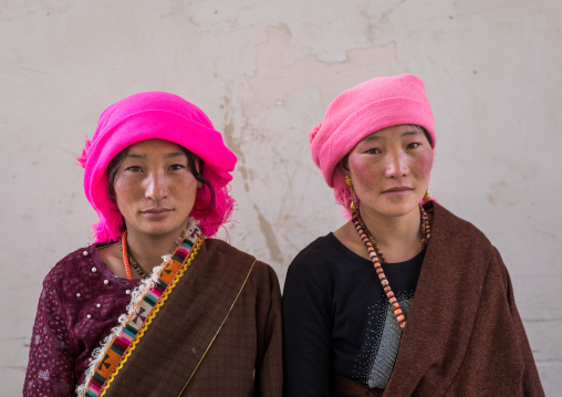 Portrait of tibetan nomads women with a pink headwears, Qinghai province, Tsekhog, China