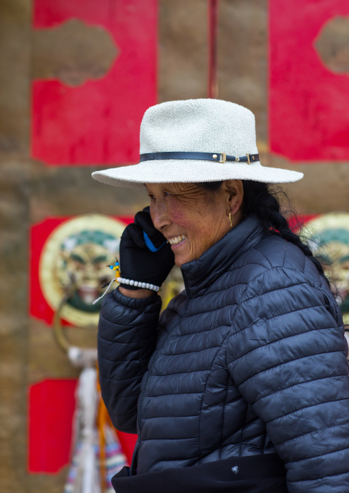Tibetan woman calling on her mobile phone in Hezuo monastery, Gansu province, Hezuo, China